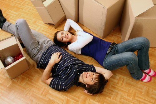 Professional movers handling boxes and furniture in a flat